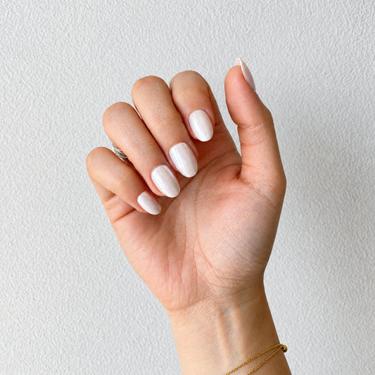 Milky white pearl chrome press-on nails curled fist pose