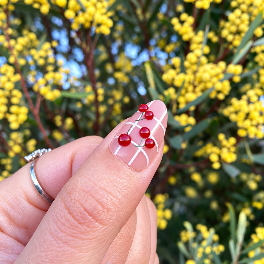Cherry detail close-up on sheer nail